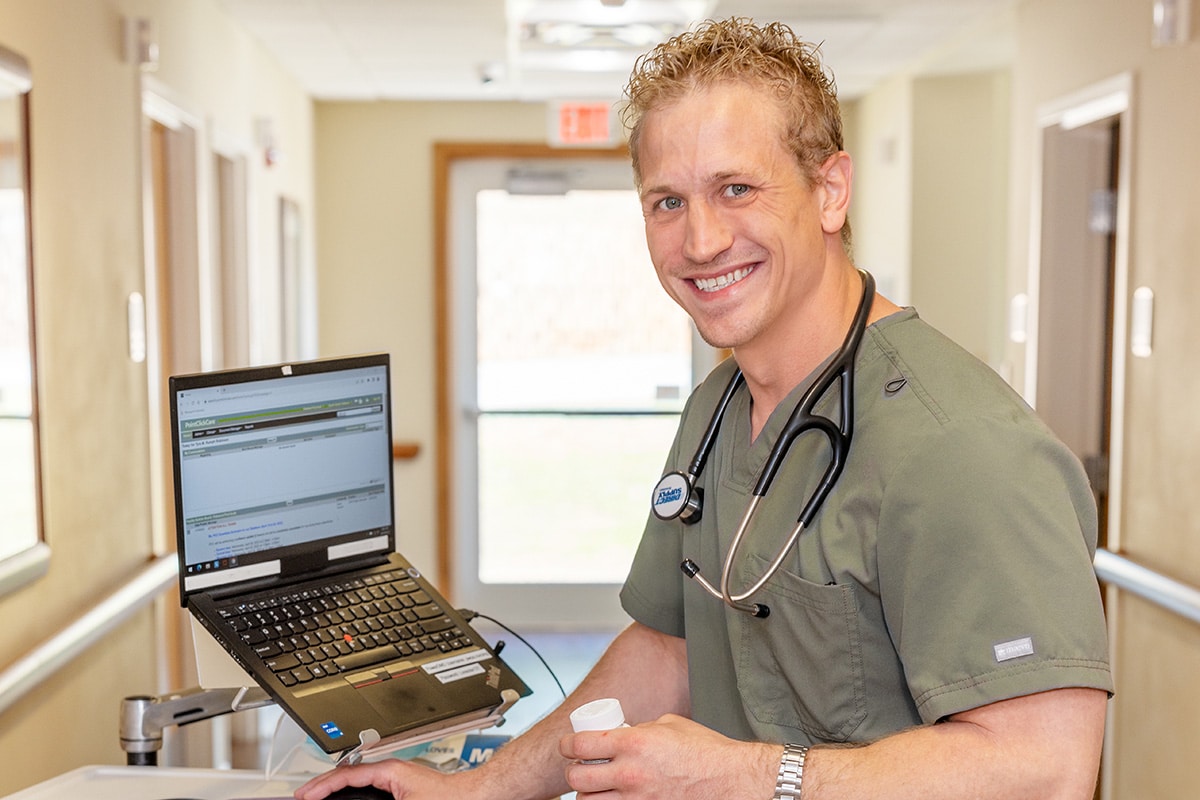 a nurse in the hallway at a nurse's cart at the Patewood Post Acute facility