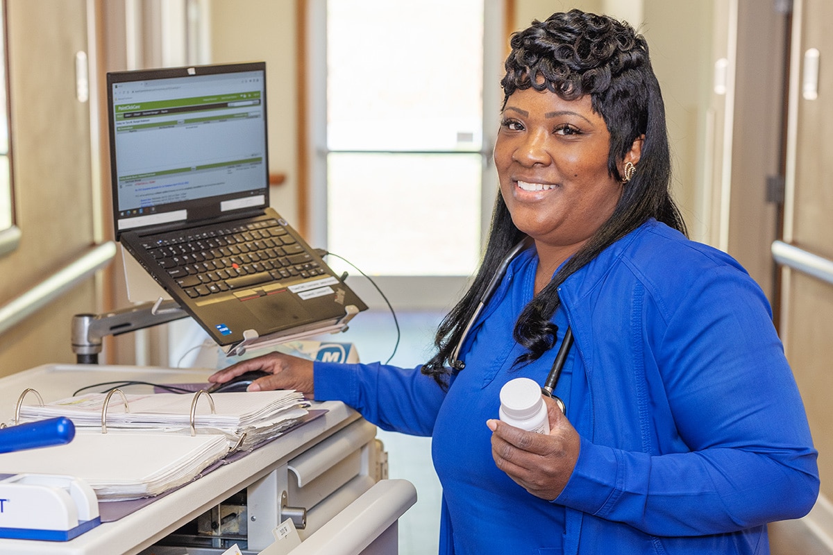 a nurse in the hallway at a nurse's cart at the Patewood Post Acute facility